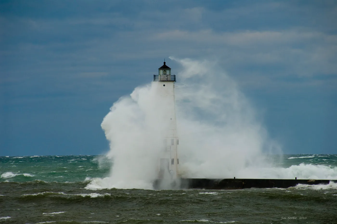 Storm waves crashing over the Frankfort lighthouse on Lake Michigan during a windstorm