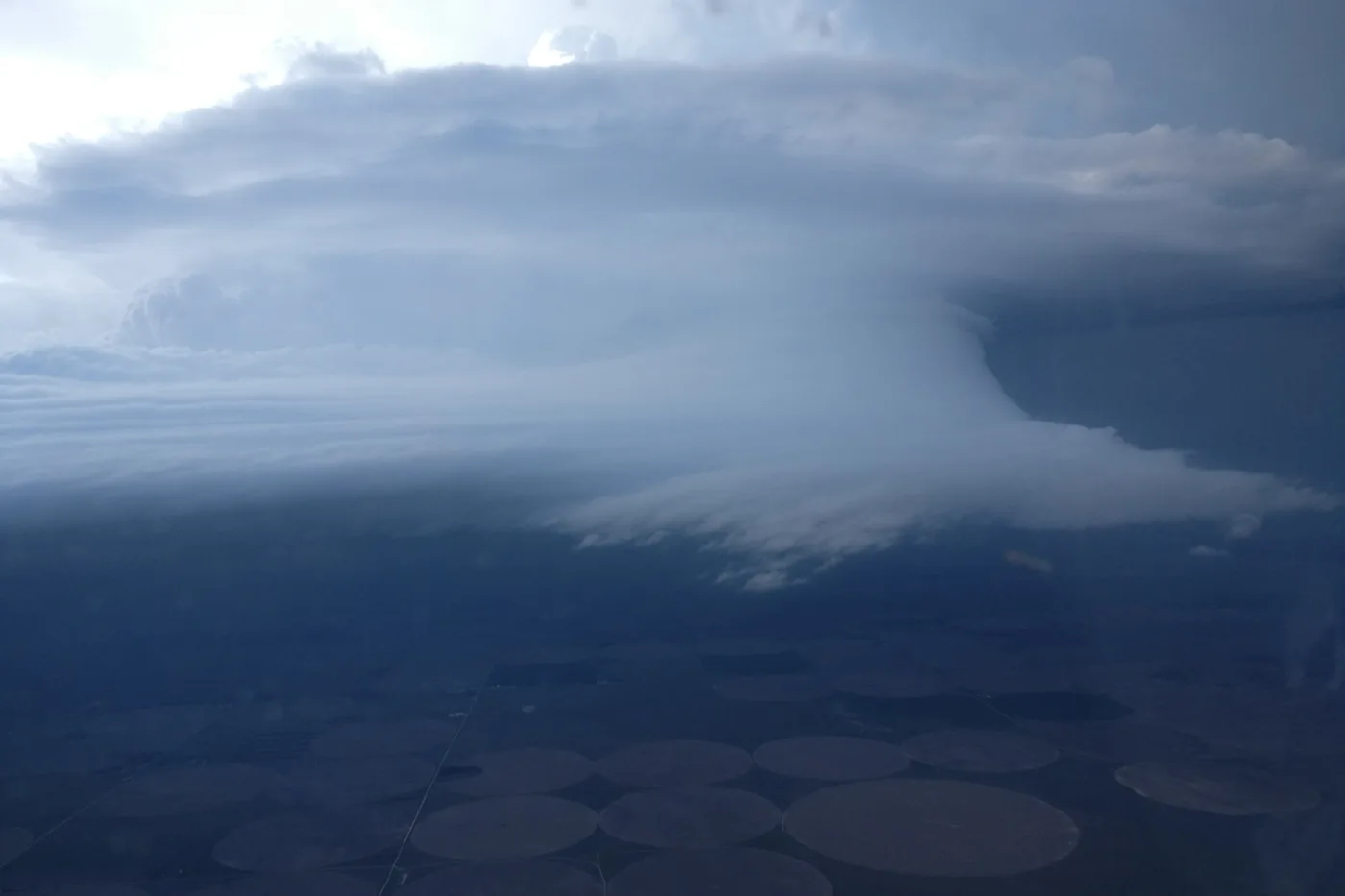 Supercell thunderstorm anvil seen from the window of a NOAA P-3 research aircraft above farm fields