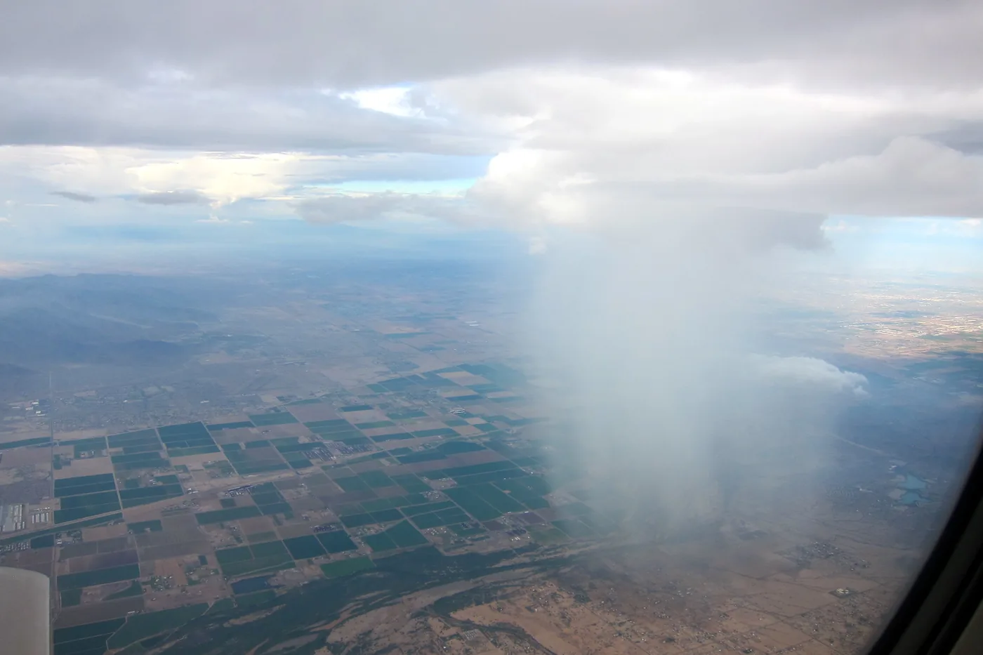 Rain shaft pouring from a storm cloud over the western suburbs of Phoenix, seen from an airplane