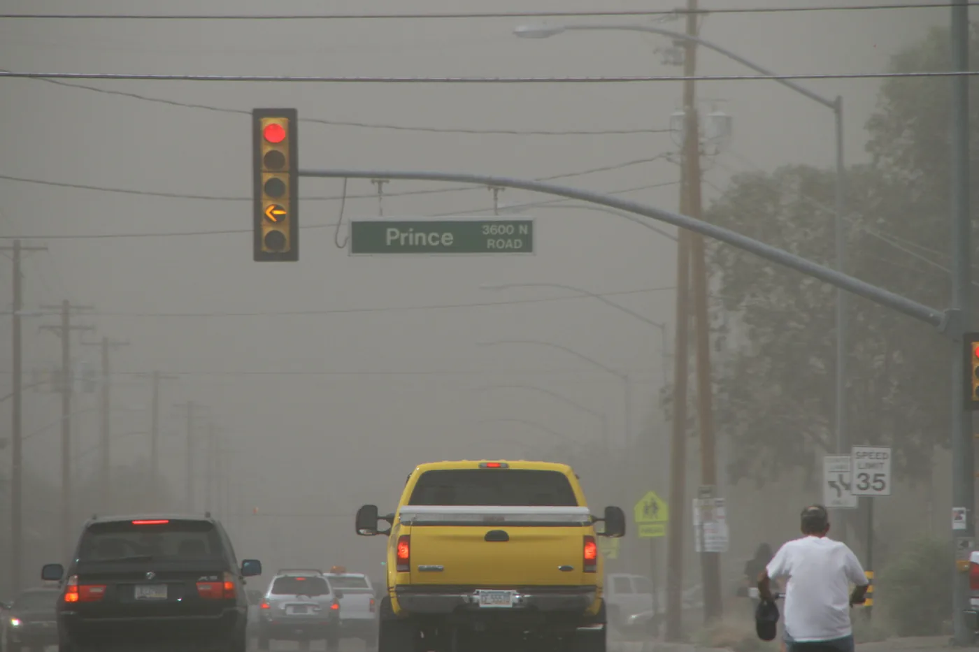 Haboob dust storm darkening the sky over traffic at a Prince Road intersection