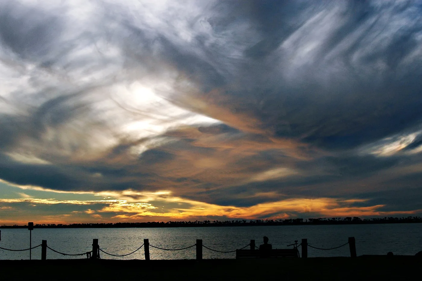Dramatic streaked clouds over the bay at dusk in Chula Vista, California