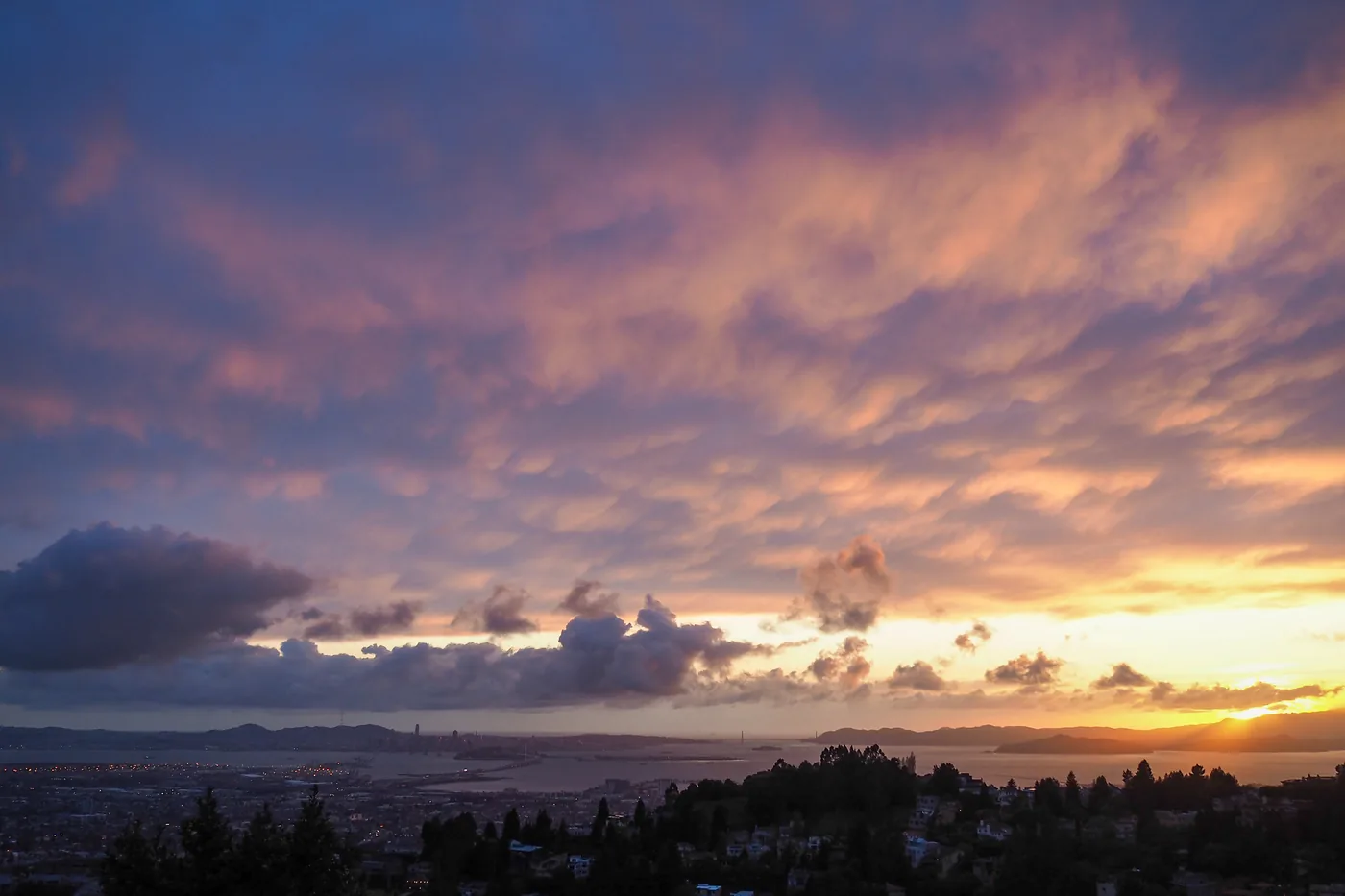 Post-storm clouds glowing at golden hour over San Francisco Bay, seen from Grizzly Peak in the Oakland Hills