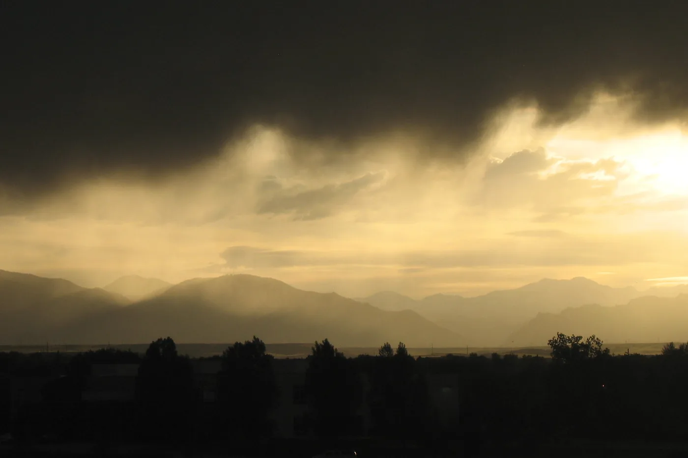 Dark storm clouds with light breaking underneath over Thornton, Colorado