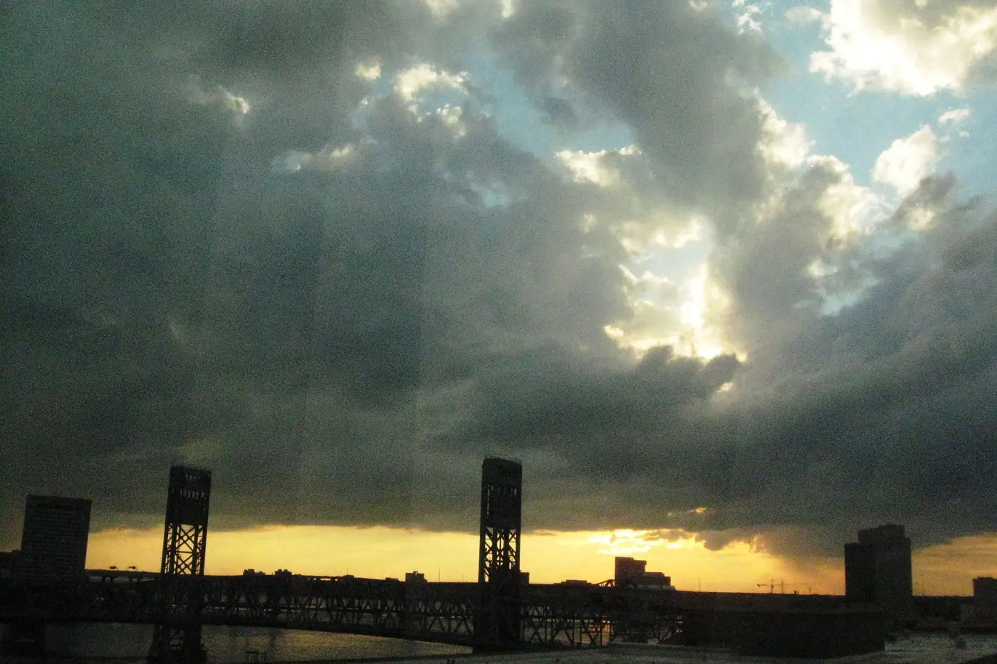 Dark clouds and breaking light over the St. Johns River and a lift bridge, seen from a hotel in downtown Jacksonville