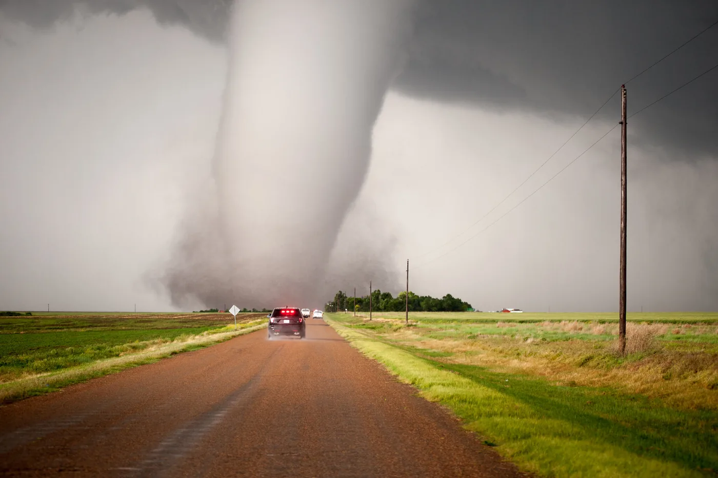 Tornado on the open plains paralleling a paved road near Dodge City, Kansas