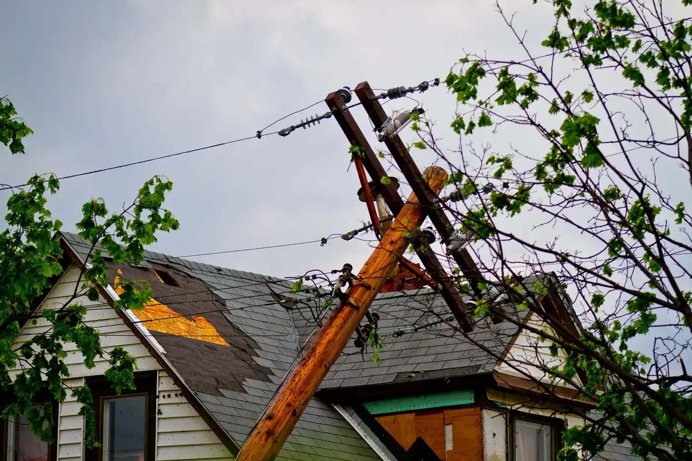 Utility pole snapped onto a damaged house roof after the May 2011 tornado in north Minneapolis