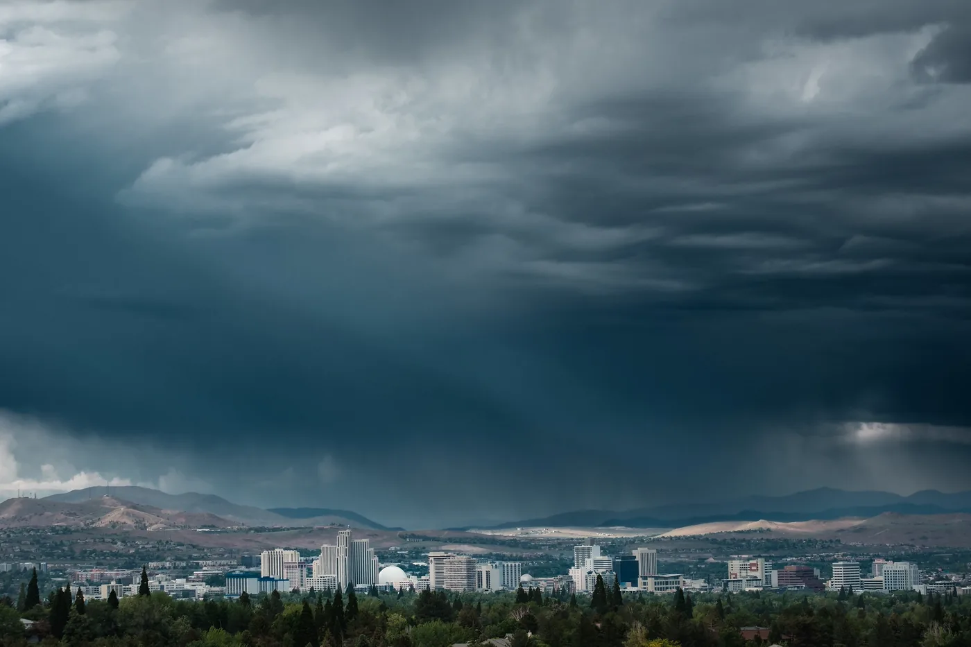 Thunderstorm with a dark rain shaft over the Reno, Nevada, skyline and surrounding hills