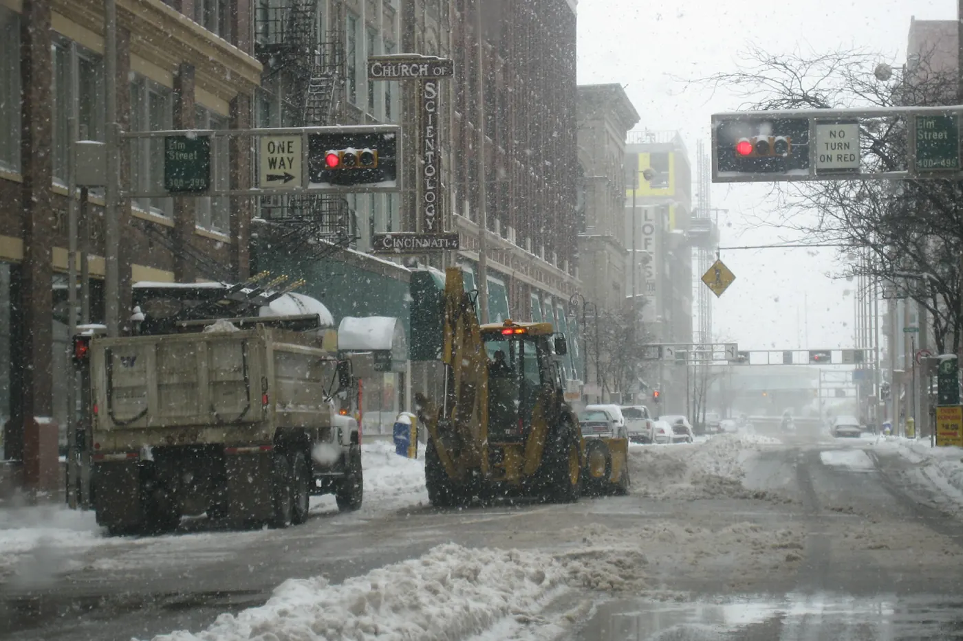 Plows and dump trucks clearing a snowstorm at 4th and Elm Streets in downtown Cincinnati