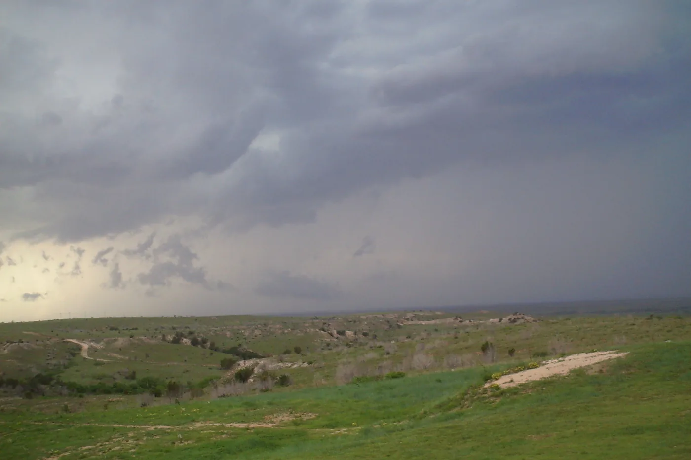 Thunderstorm with rain falling over the rolling grassland just east of Amarillo, Texas