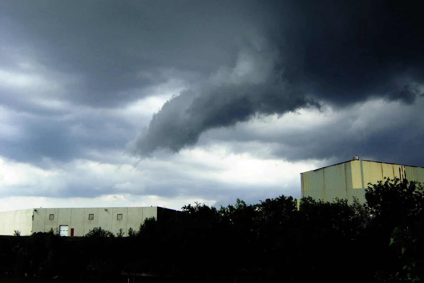 Funnel cloud lowering from a dark storm east of downtown Houston, Texas