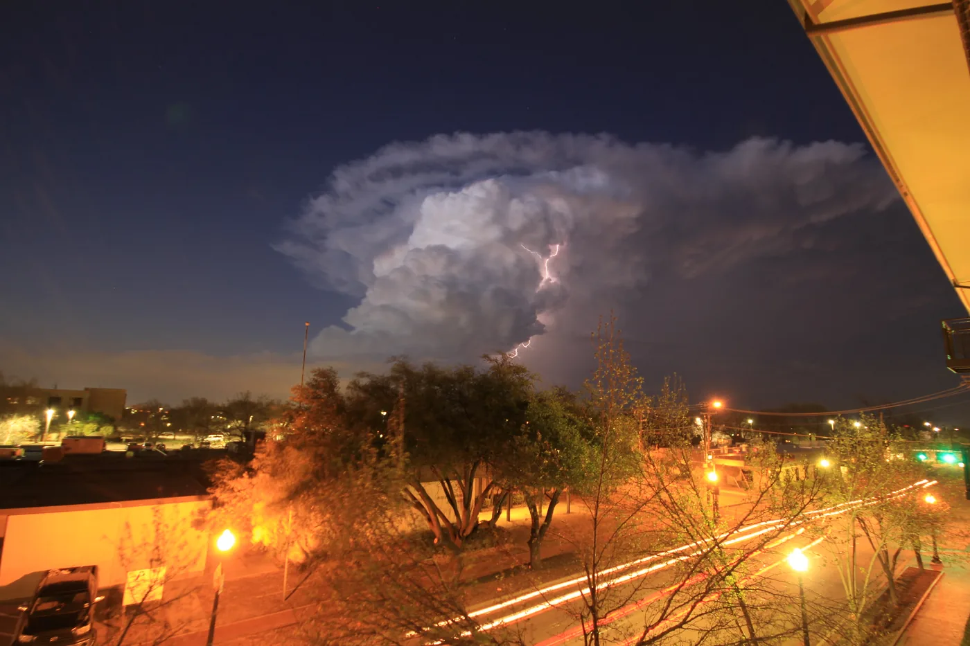 Lightning illuminating a towering storm cloud over Plano, Texas, at night