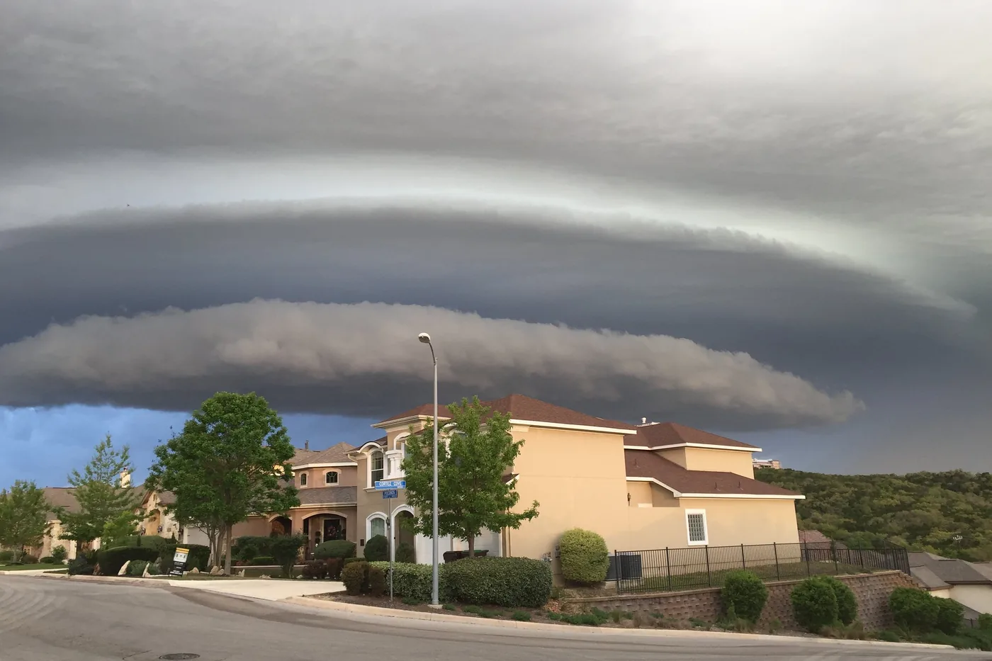 Morning shelf cloud stretching over homes and a street in San Antonio, Texas