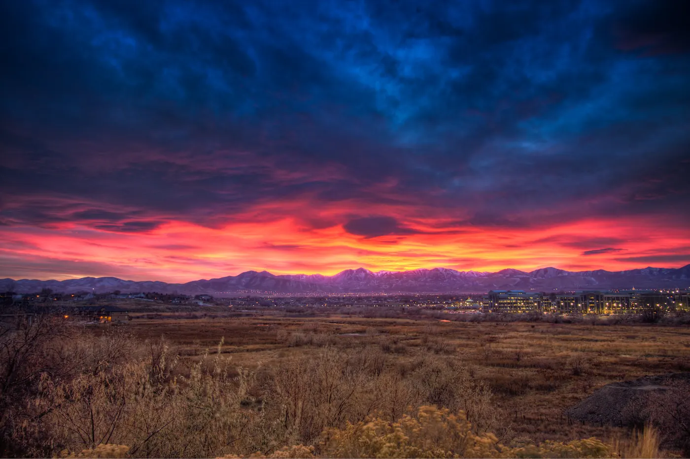 Storm clouds lit red and orange at sunset over South Jordan, Utah