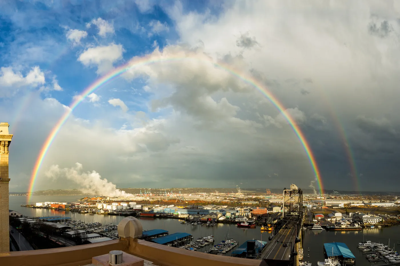 Double rainbow under breaking storm clouds over the Port of Tacoma, Washington