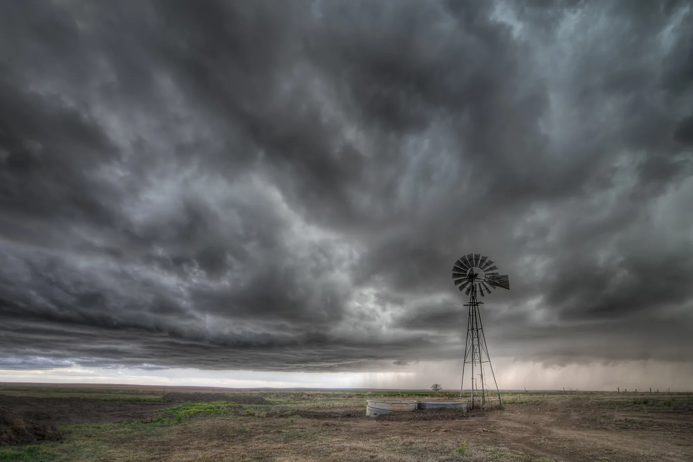 Windmill under a dark thunderstorm sky on the High Plains of western Kansas
