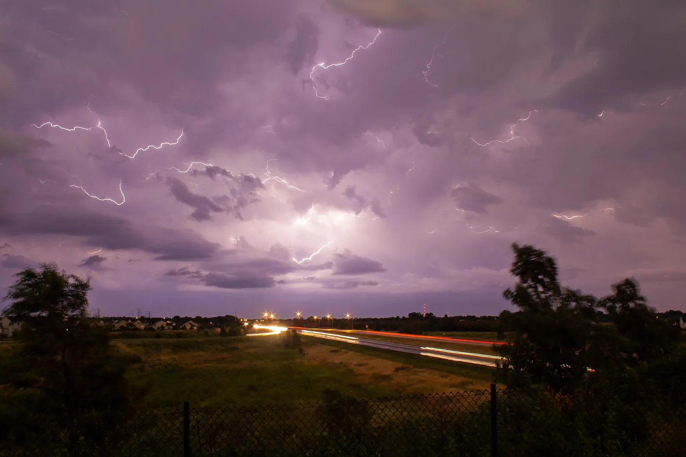 Cloud-to-cloud lightning branching over highway traffic at dusk in Minnetonka, Minnesota