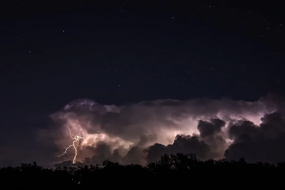 Lightning flashing inside a long bank of storm clouds at night in Missouri