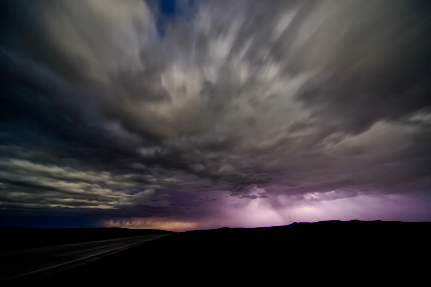 Overnight thunderstorm with lightning under streaked clouds over the North Dakota plains