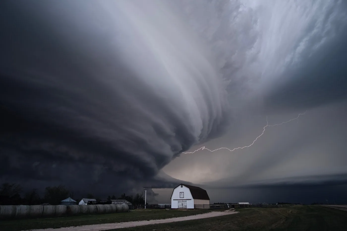 Supercell thunderstorm with lightning over farm buildings near Imperial, Nebraska
