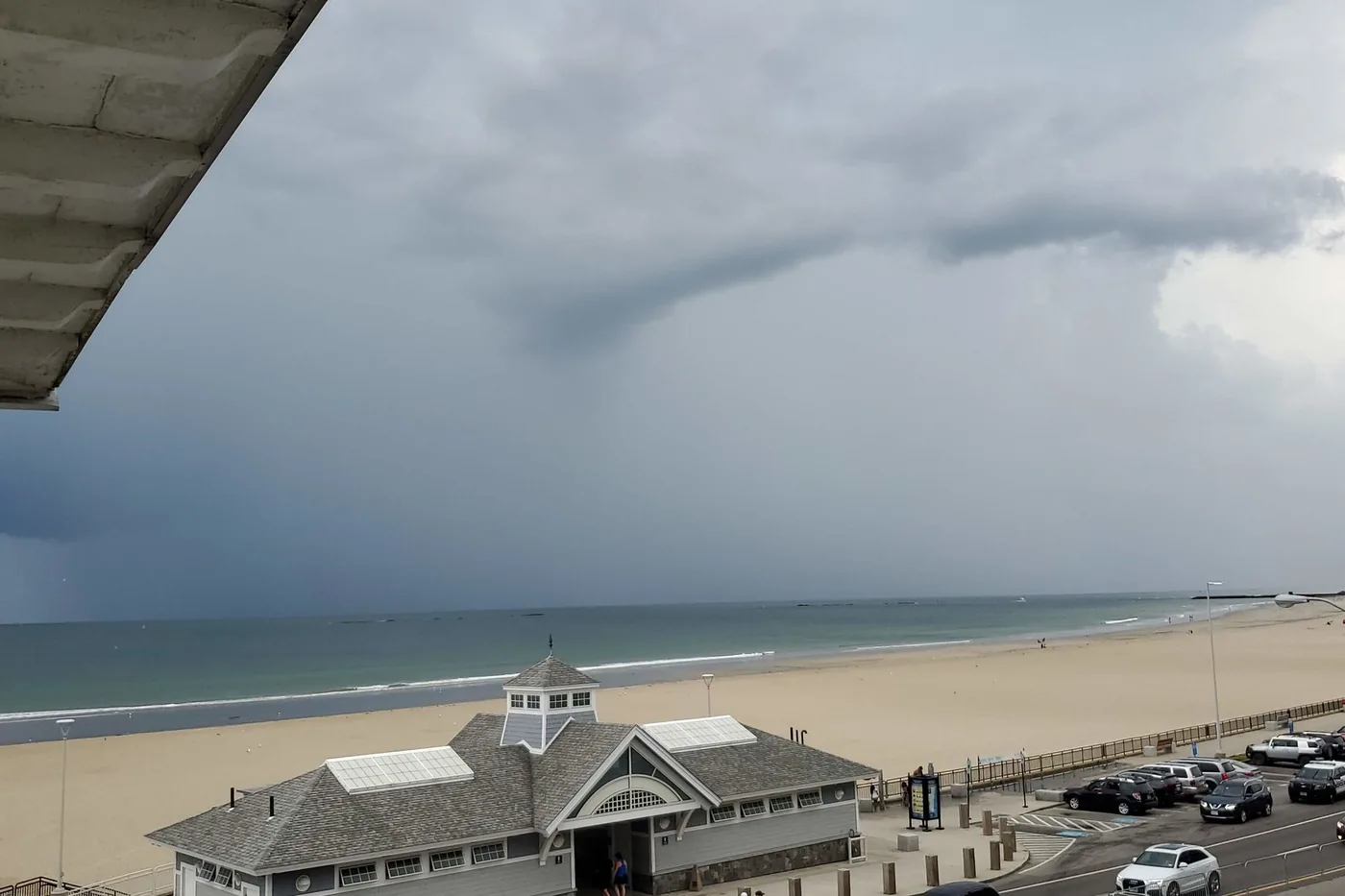 Storm clouds and a distant rain shaft over the beach and boardwalk at Hampton Beach, New Hampshire