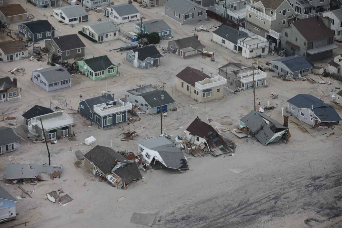 Aerial view of sand-covered, damaged homes along the New Jersey shore after Hurricane Sandy