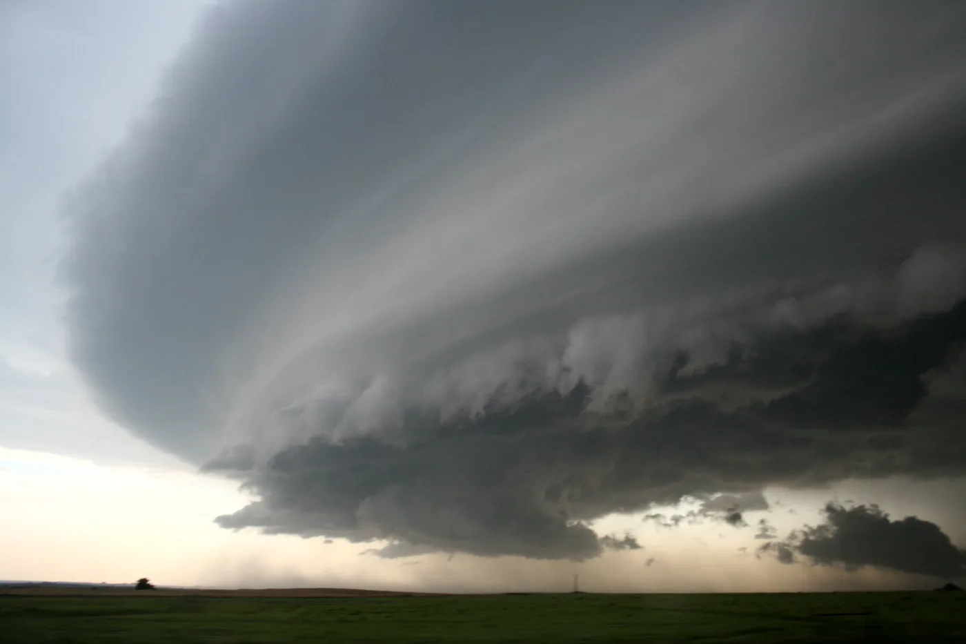 Supercell thunderstorm with a sculpted, rotating base over flat farmland in Oklahoma