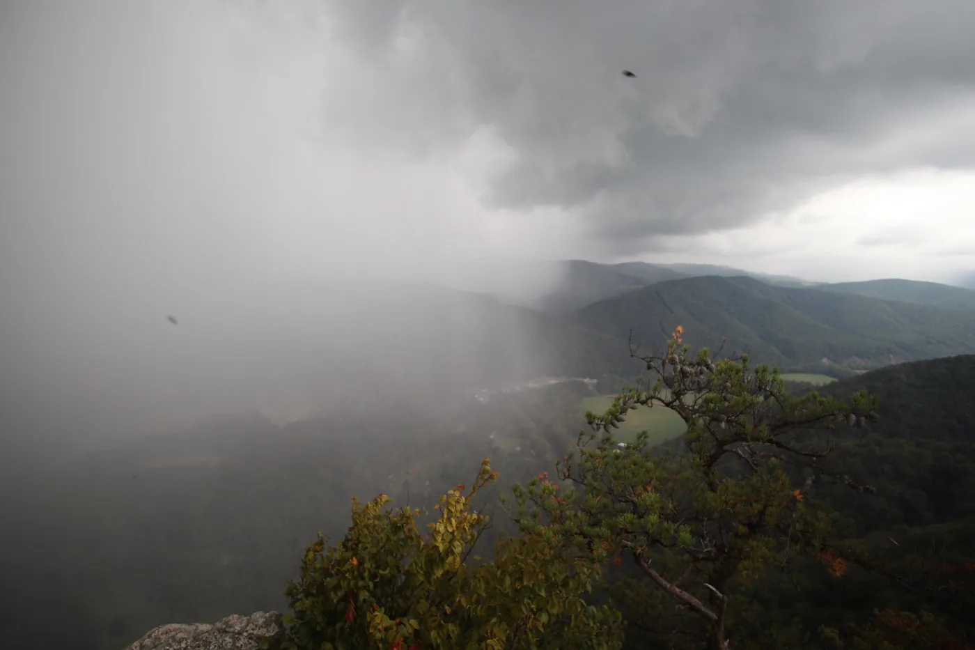 Curtain of rain from a storm sweeping across forested mountain ridges and a valley in West Virginia